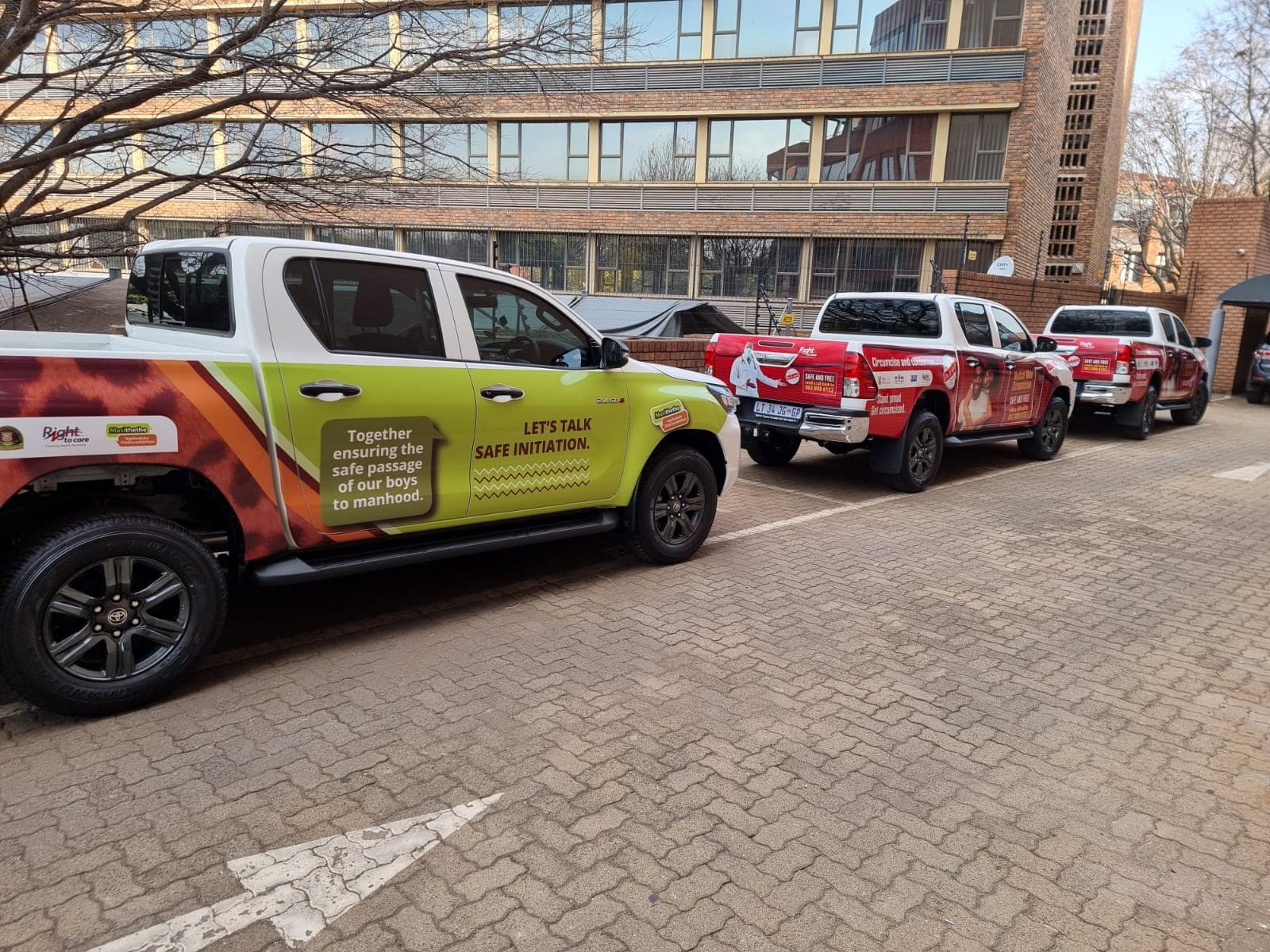 Row of branded Toyota Hilux bakkies with full-colour campaign wraps